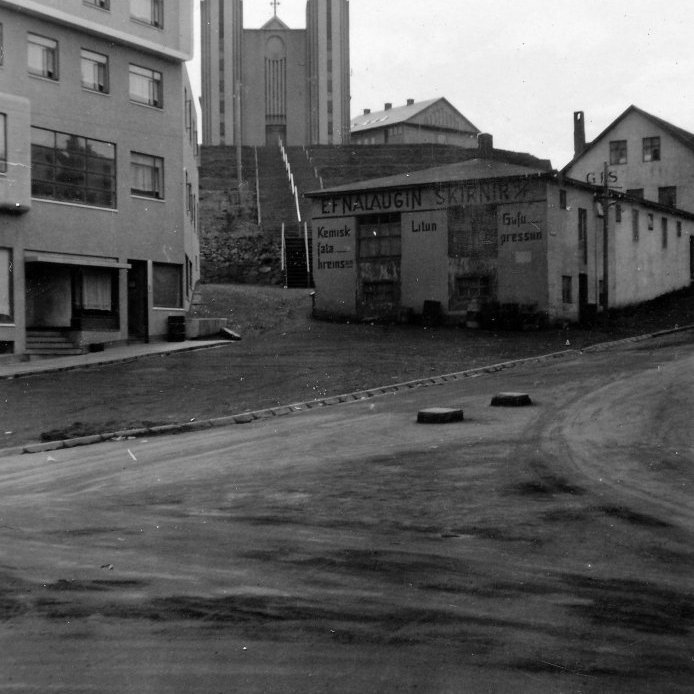 102. Horft upp kirkjutröppurnar árið 1942, þó vantar neðstahluta þeirra. Hesthús gistihússins Carolinu Rest stóð í vegi fyrir því að hægt væri að klára þær og var rifið skömmu eftir að þessi ljósmynd var tekin. Ljósmynd Jón Sigmundsson.