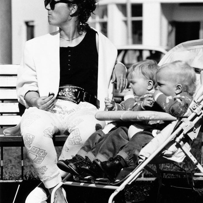 103. Brynja Agnarsdóttir með tvíburana sína á góðviðrisdegi á Ráðhústorgi árið 1988. Takið eftir Mixdósinni en innihald hennar á rætur sínar að rekja til gosdrykkjaframleiðslu Flóru um 1960 sem staðsett var í Kaupvangsstræti. Þar réði Björgvin Júníusson , Baddi Júnn, ríkjum og sagan segir að hann hafi þróað Mixdrykkinn á gestum í afmælum barna sinna. Þegar allir gestirnir voru orðnir sammála um að drykkurinn væri góður var Mixið sett á markað og selt í Kaupfélaginu og hjá Oddi í Höfn. Ljósmynd Tómas L Vilbergsson.