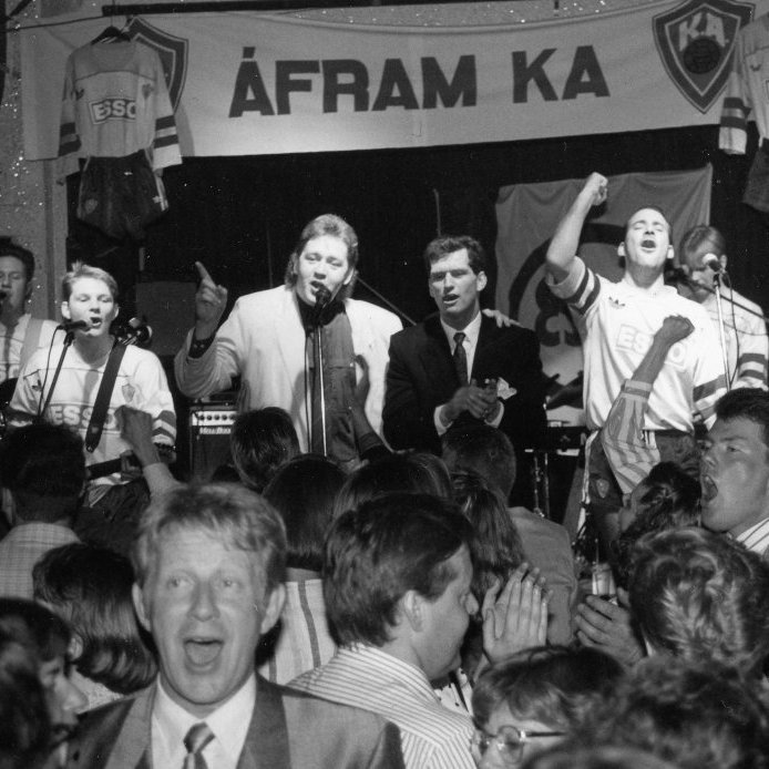 35. KA menn fagna Íslandsmeistaratitli í fótbolta í Sjallanum1989. Þórsarinn Bjarni Hafþór Helgason söng eigið lag og texta „Áfram KA-menn“ og hafði sér til aðstoðar þjálfara liðsins Guðjón Þórðarson. Um undirleik sá hljómsveitin Skriðjöklar. Ljósmynd úr safni Dags.