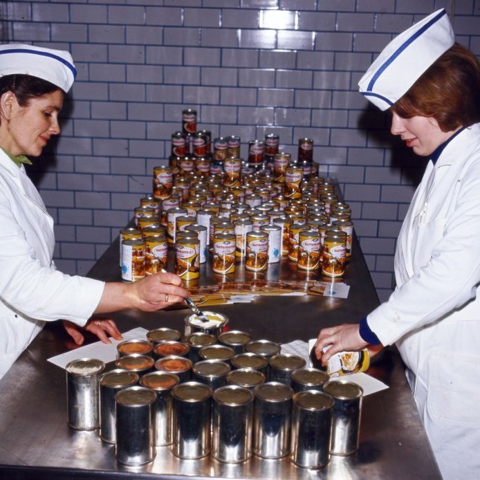 61. Niðursuðudósirnar með nautasmásteikunum urðu óneitanlega fallegri eftir að konurnar höfðu límt miðana á þær árið 1966. Helstu tegundir Kjötiðnaðarstöðvar KEA voru: kjötbúðingur, bæjarbjúgu, steikt lifur, kindakjöt (soðið), nautakjöt (soðið, smásteik, saxbauti) ennfremur kindakæfa og lifrarkæfa. Ljósmynd Gunnlaugur P. Kristinsson.