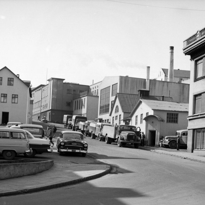 78. Kaupvangsstræti eða Grófargil sem oft var nefnt Kaupfélagsgilið á þessum tíma þar sem í gilinu voru helstu framleiðslufyrirtæki KEA staðsett í þessum tíma. Mjólkurbílarnir eru í röð meðfram gangstéttinni meðan bílstjórarnir raða í þá kössum og pinklum til að keyra út í sveitunum. Ljósmynd Erlingur Davíðsson.