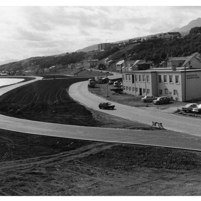 84. Drottningarbraut í byggingu um 1980. Hitaveita Akureyrar var til húsa í gamla prentsmiðjuhúsi POB. Ljósmynd úr safni Dags. 85. Drottningabraut verður til um 1970 fyrir framan Laxdalshús. Ljósmynd Haraldur Sigurgeirsson.