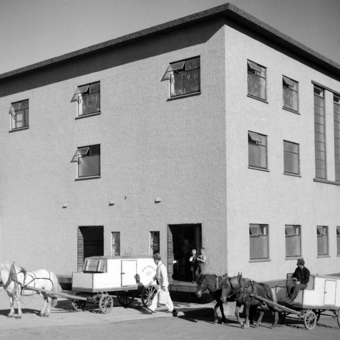 97. Hestvagnar við Mjólkursamlag KEA í Kaupangsgili árið 1939, nú Listagil. Mjólkursamlagið sá um heimsendingu mjólkur á flöskum til bæjarbúa frá upphafi. Vagnarnir fluttu mjólkurflöskur í heimahús. Ljósmynd Eðvarð Sigurgeirsson.