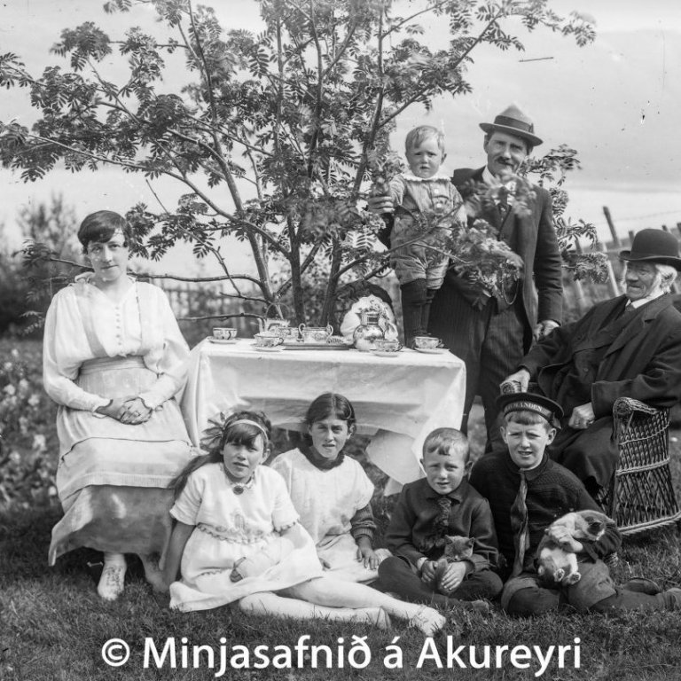 Séra Matthías Jochumsson í heimsókn hjá syni sínum, Steingrími lækni og Kristínu Thoroddsen konu hans og börnum þeirra. Sitjandi á grasinu frá vinstri: Anna, barnfóstran, Jón og Baldur. Þorvaldur stendur á borðinu hjá föður sínum. Myndin er tekin árið 1919 í garði læknishússins. Matthías lést árið 1920.