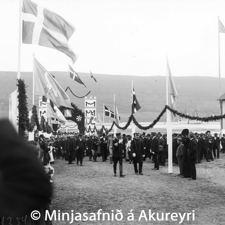 Konungskoman árið 1907. Friðrik VIII Danakonungur stígur á land á Torfunefsbryggju 13. ágúst ásamt föruneyti sínu. Guðlaugur Guðmundsson sýslumaður gengur honum við hlið.