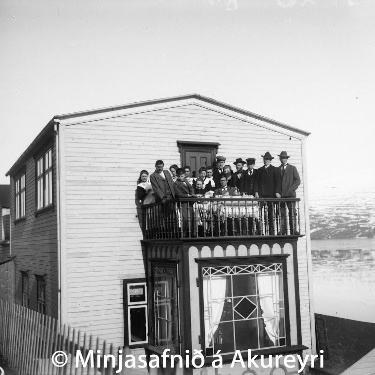 Hafnarstræti 64. Fjölskylda Boga Daníelssonar ásamt gestum á svölum hússins. Í garði þessa húss var um 60 ára skeið brjóstlíkan af konu, gert úr tré. Bogi keypti þetta stafnslíkan árið 1903 úr frönsku skipi, La Glaneuse, sem dæmt var ósjófært. Hafnarsjóður keypti skipið á uppboði og var það notað við stækkun hafnarbryggjunnar á Akureyri. Var skipið fyllt grjóti og því sökkt, svo að það myndaði bryggjuhausinn. Bjarni Einarsson skipasmiður sá um verkið og var því lokið árið 1903. Konumyndin er nú varðveitt á Minjasafninu á Akureyri og er hluti sýningarinnar Land fyrir stafni – Íslandskortasafn Schulte.
