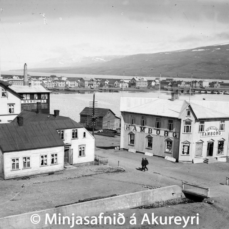 Miðbær Akureyrar 1910. Verslunin Hamborg, Hafnarstræti 94, nýreist. Til vinstri eru fyrstu húsin, sem byggð voru á Torfunefi árið 1894, íbúðarhús Bjarna Einarssonar skipa- og bryggjusmiðs og Dúa Benediktssonar lögregluþjóns (viðbyggingin er frá 1900). Á bakvið þau eru hús Jakobs Karlssonar Hafnarstræti 93, oftast kallað Jerúsalem, byggt árið 1907 en brann 1945. Þar var fyrsta afgreiðsla Eimskipafélags Íslands.
