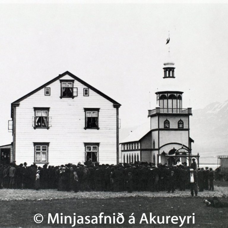 Þingmálafundur á Grund í Eyjafirði. Til vinstri er íbúðar- og verslunarhús Magnúsar Sigurðssonar, bónda og kaupmanns, byggt árið 1893. Þá er Grundarkirkja, sem Magnús reisti árið 1905. Hún er ein stærsta kirkja í sveit á Íslandi og þykir meðal þeirra fegurstu. Lengst til hægri er Grundarbíllinn, sem Magnús keypti árið 1907.