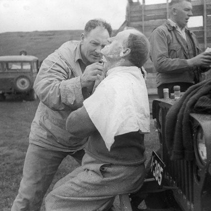 Jón Sigurgeirsson frá Helluvaði að raka mann, að baki honum er sennilega Björn Guðmundsson lögregluþjónn.