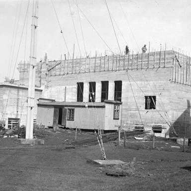 Myndin er tekin þegar samkomuhús Vestmannaeyja var byggt á árunum 1936-38. Mastrið í forgrunni myndarinnar er af öðru loftnetsmastri Loftskeytastöðvarinnar í Vestmannaeyjum. Það var fjarlægt er það hafði lokið hlutverki sínu 1962-64.