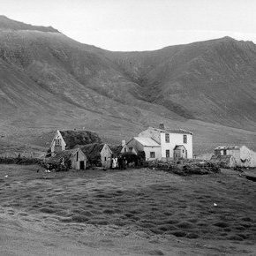 Efsti Hvammur í Dýrafirði.
Steinhúsið byggt á grunni hægri hluta torfbæjarins. Þilin snúa til austurs. Þversum að bæjarbaki er baðstofa, á öðru húsi frá vinstri eru bæjardyr, þá skemma og lengst t.h. er eldiviðargeymsla (mógeymsla). Skúrinn við steinhúsið er matvælageymsla (búr). Timburbyggingin lengst. t.h. er hlaða sem var svo gisin að hún virkaði eins og súgþurrkunarhús. Kálgarður er framan við bæinn og framan við hann Hlaðbrekka Hvítklæddu konurnar eru: Ágústa Guðjónsdóttir og Ingibjörg Kristjánsdóttir. Sveinn Þorvaldsson silfur og gullsmiður 1798-1834 bjó þarna. Þarna bjuggu tvær fjölskyldur er myndin var tekin líklega á milli 1935-´40.