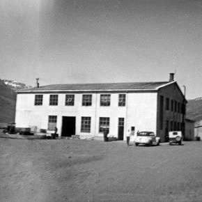 Hraðfrystihús Eskifjarðar. Til hægri má sjá Gömlu búð áður en hún var færð núverandi stað. Fremst til hægri á myndinni sjást mjólkurbrúsar hangandi á grindverki bakarísins.