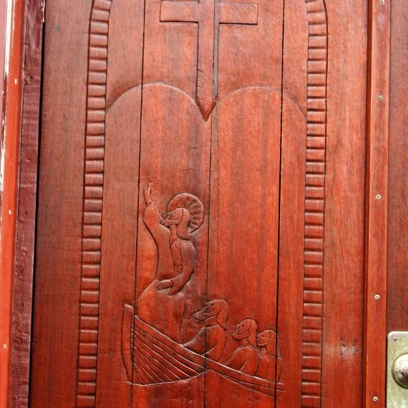 Nyðri kirkjuhurð Miðgarðakirkju. Útskurður eftir Einar Einarsson. Jesú á bát. Undir myndinni stendur: Og hann vaknaði og hastaði á vindinn. Mark. 4.39. 
Úr Grímseyjarsafni Helga Daníelssonar og Friðþjófs Helgasonar.